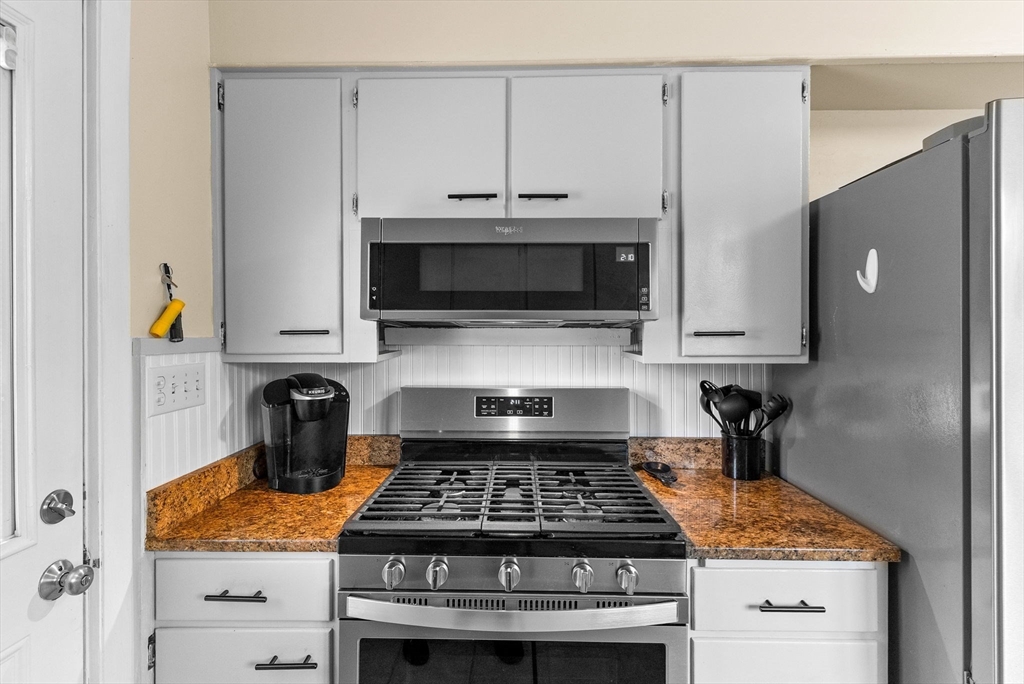 60 Goshen Road Dedham, MA 02026 - Photo 10 of 37 a kitchen with stainless steel appliances granite countertop a stove and a microwave