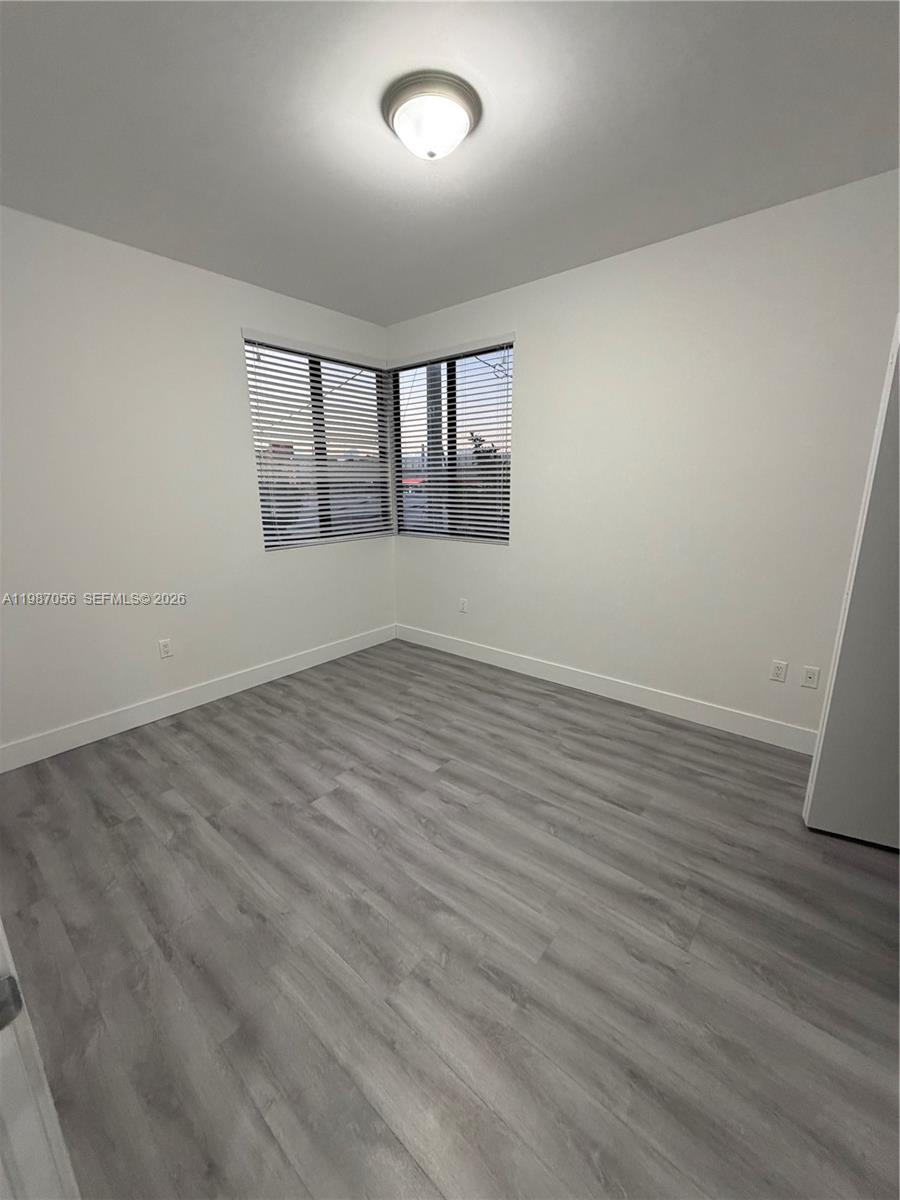 859 East 24th Street, Unit 404 Hialeah, FL 33013 - Photo 6 of 18 wooden floor in an empty room with a window