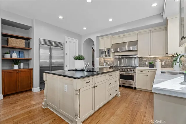 a kitchen with kitchen island white cabinets and refrigerator