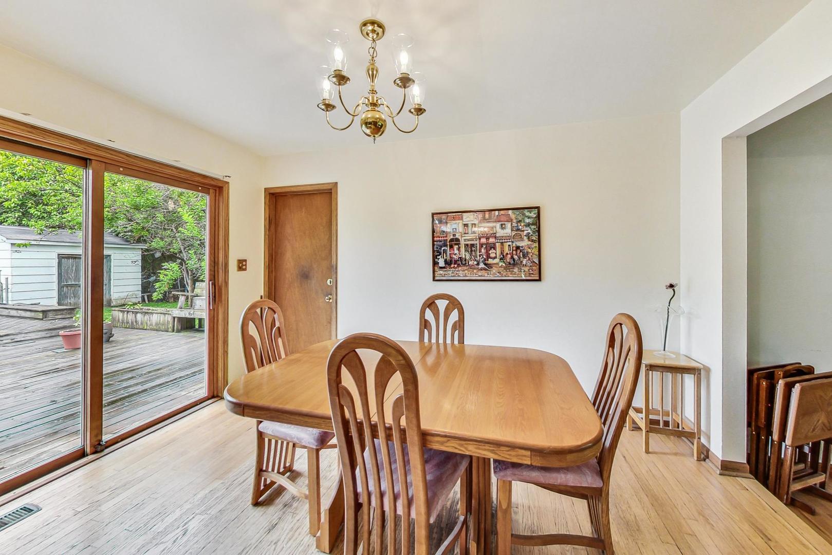5701 Lenox Road Lisle, IL 60532 - Photo 7 of 24 a view of a dining room with furniture a chandelier and wooden floor