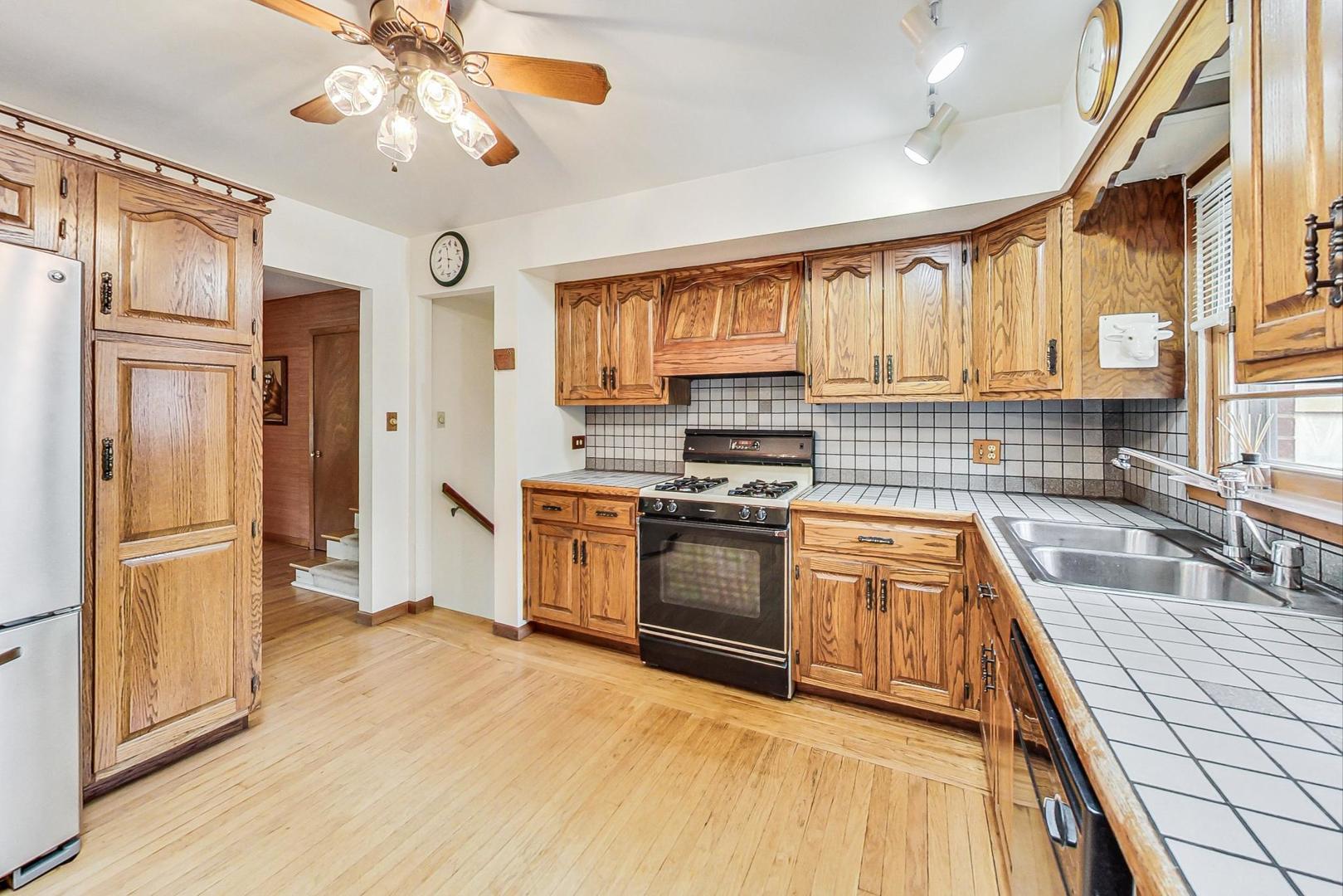 5701 Lenox Road Lisle, IL 60532 - Photo 9 of 24 a kitchen with stainless steel appliances granite countertop a refrigerator a stove and a sink with cabinets