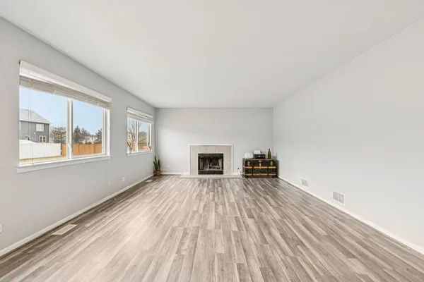 wooden floor fireplace and windows in an empty room