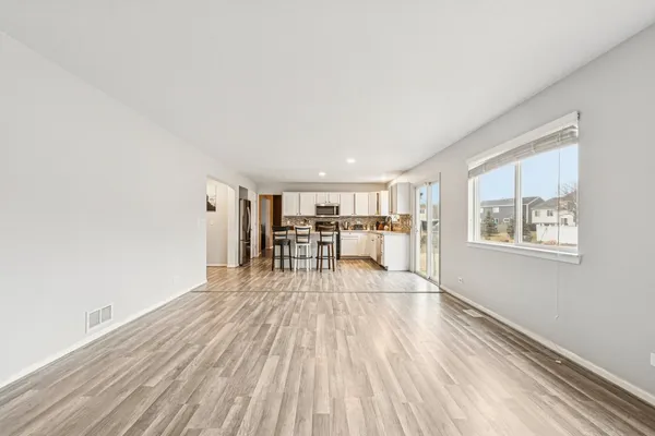 a view of a livingroom with wooden floor and furniture