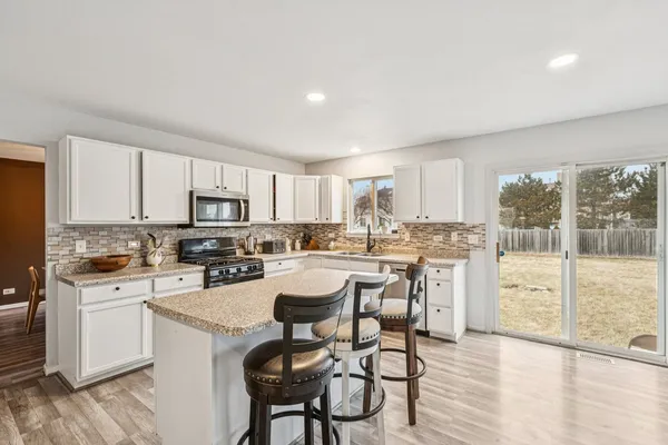 a kitchen with a table chairs stove and cabinets