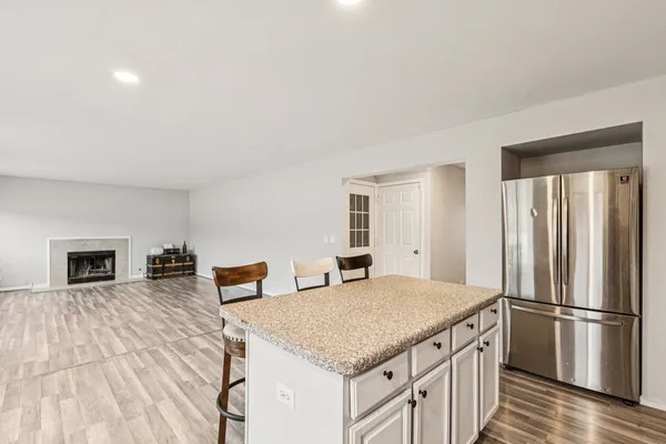 a kitchen with stainless steel appliances granite countertop a refrigerator a stove and a wooden floors