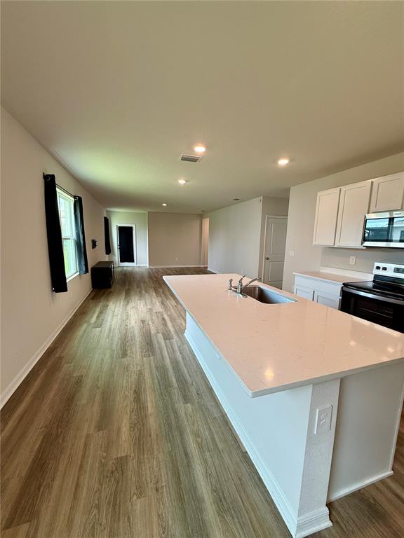 3222 Bitterroot Lane Bradenton, FL 34211 - Photo 11 of 34 a large white kitchen with wooden floor and floors