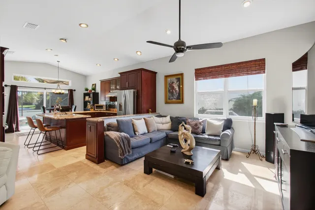 a living room with furniture a ceiling fan and a window