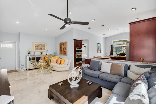a living room with furniture a flat screen tv and kitchen view