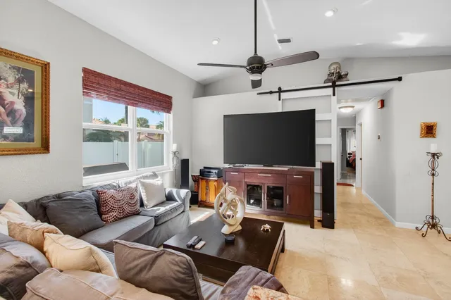 a kitchen with stainless steel appliances a refrigerator a stove a sink a dining table and chairs