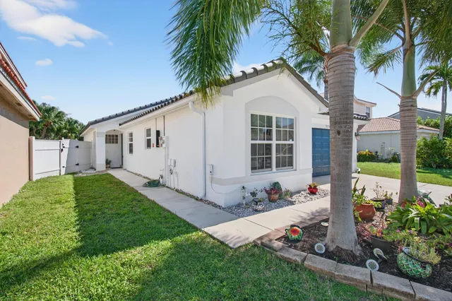 a front view of a house with a large window and potted plants