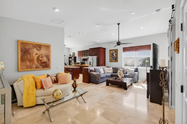 a living room with furniture a fireplace and a chandelier