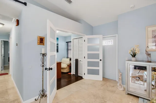 a living room with furniture kitchen view and a large window