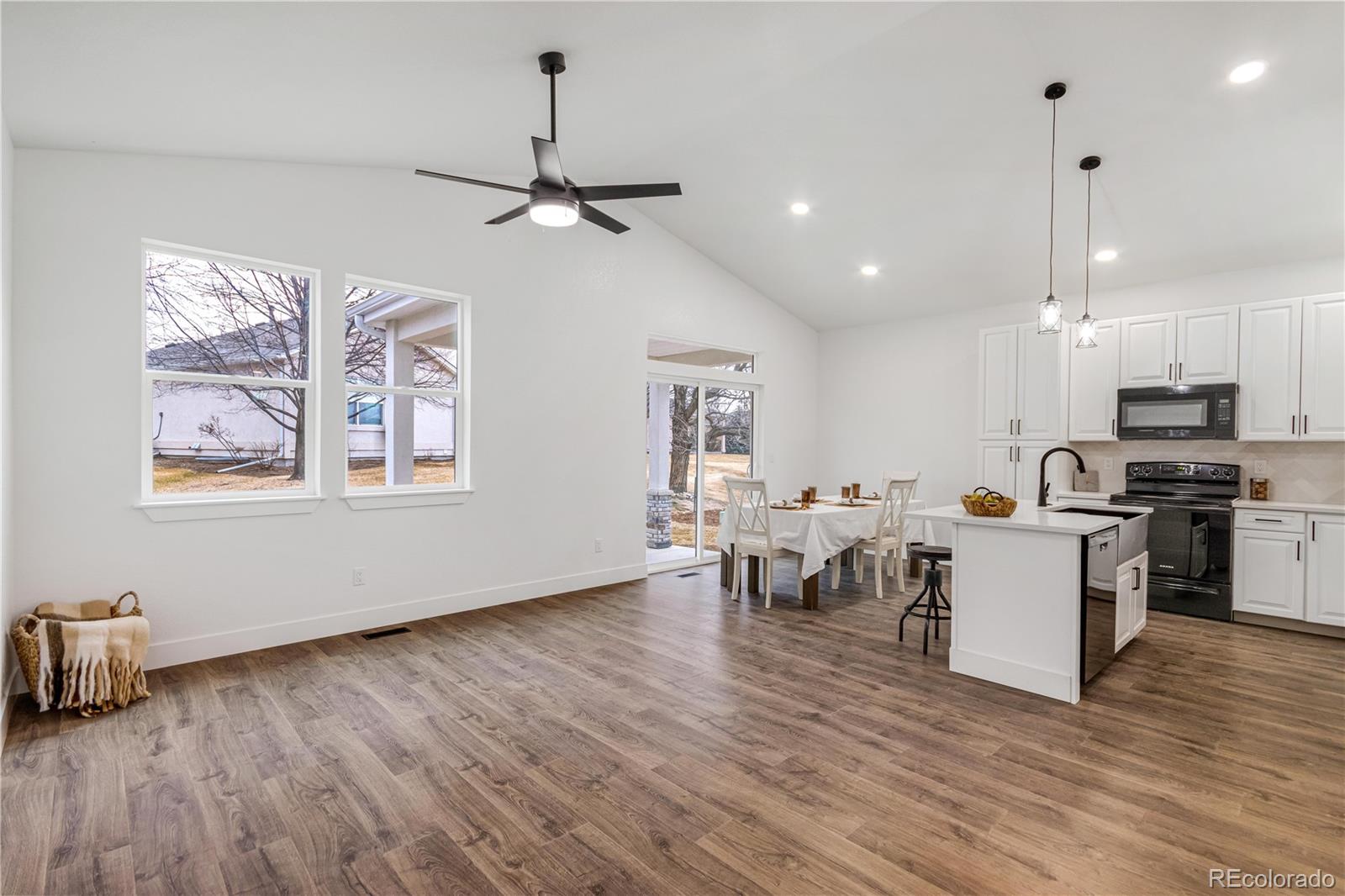 1230 Swainson Road Eaton, CO 80615 - Photo 11 of 35 a kitchen with a wooden floor dining table chairs and kitchen view