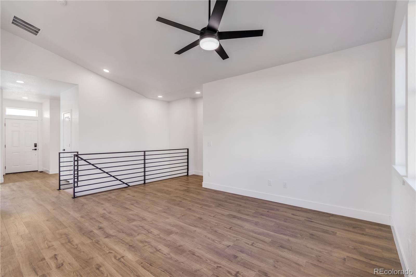1230 Swainson Road Eaton, CO 80615 - Photo 16 of 35 an empty room with wooden floor fan and windows