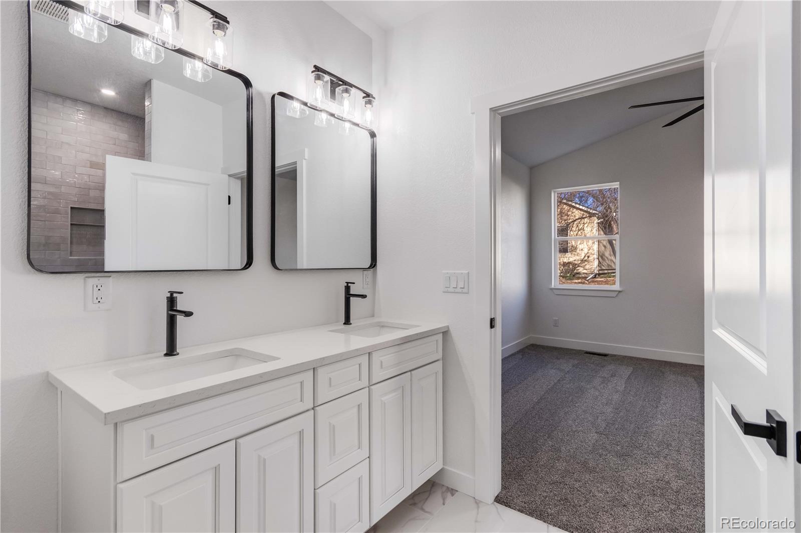 1230 Swainson Road Eaton, CO 80615 - Photo 22 of 35 a bathroom with a double vanity sink and mirror
