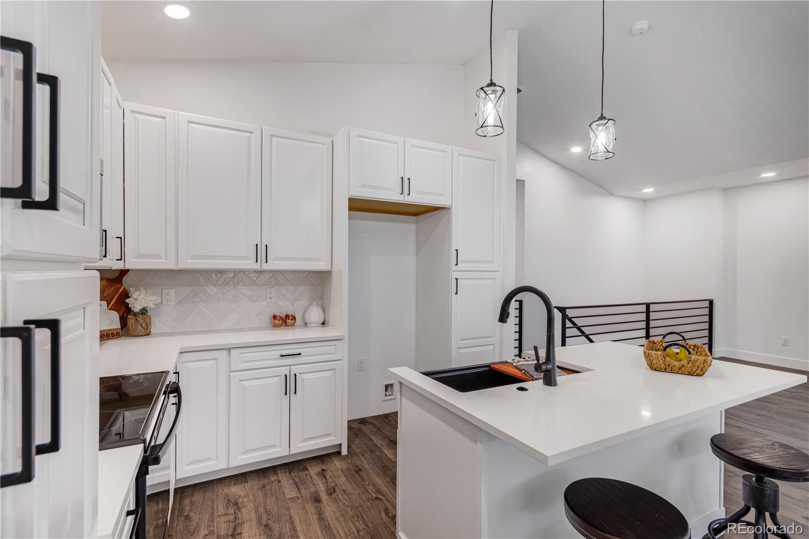 1230 Swainson Road Eaton, CO 80615 - Photo 9 of 35 a kitchen with stainless steel appliances a sink a stove a refrigerator a dining table and chairs with wooden floor