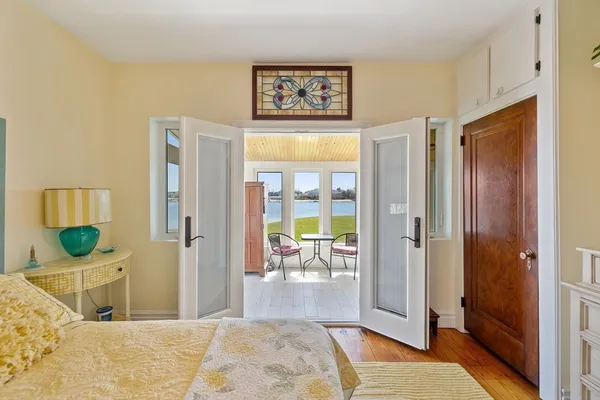 a view of a livingroom with wooden floor and a bedroom