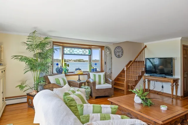 a living room with furniture a flat screen tv and a large window