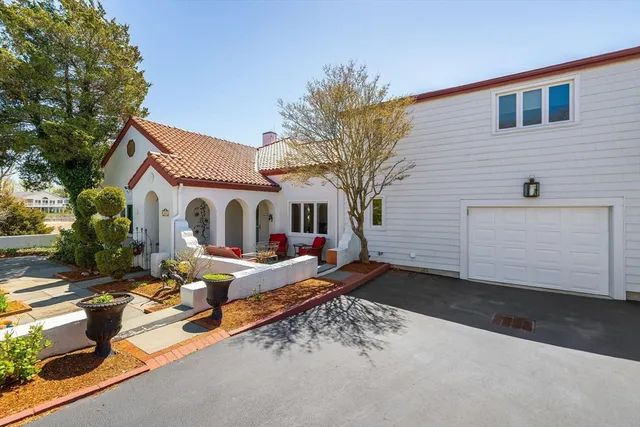 a view of a white house with yard and sitting area