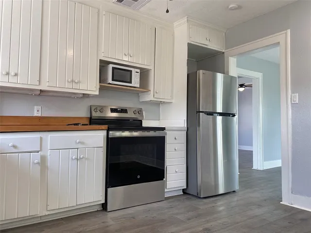 a kitchen with stainless steel appliances granite countertop a refrigerator and a stove top oven