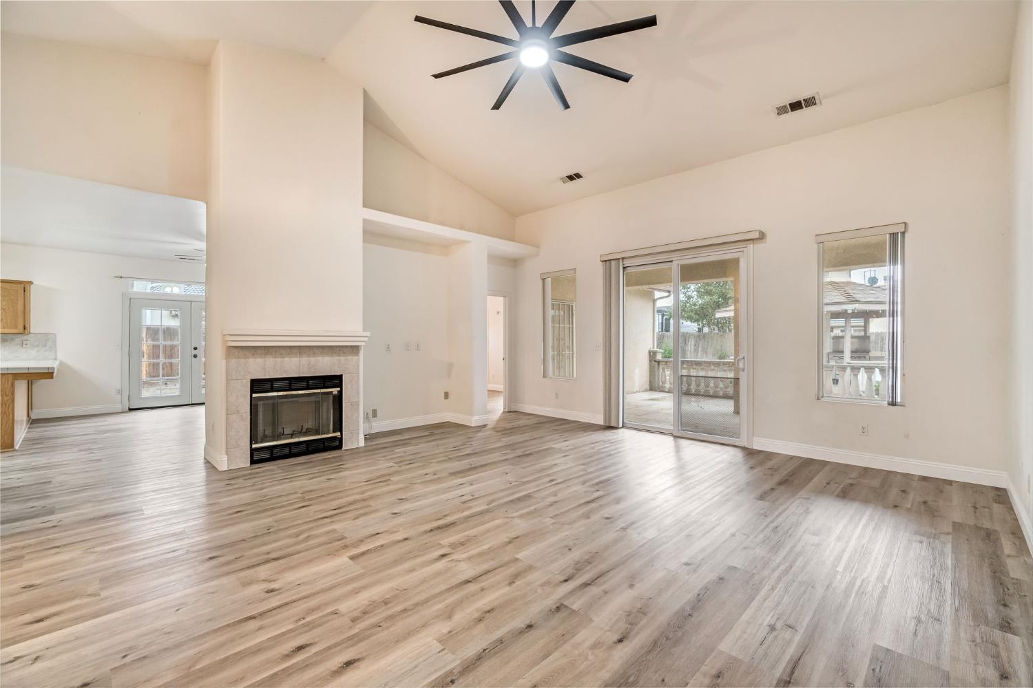2095 Independence Place Hanford, CA 93230 - Photo 21 of 35 an empty room with wooden floor fireplace and windows