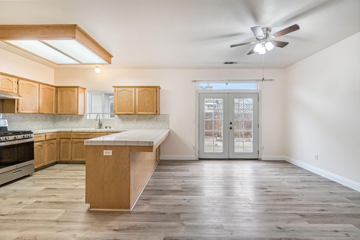 2095 Independence Place Hanford, CA 93230 - Photo 24 of 35 a large kitchen with stainless steel appliances granite countertop a stove a sink dishwasher and a refrigerator with wooden floor