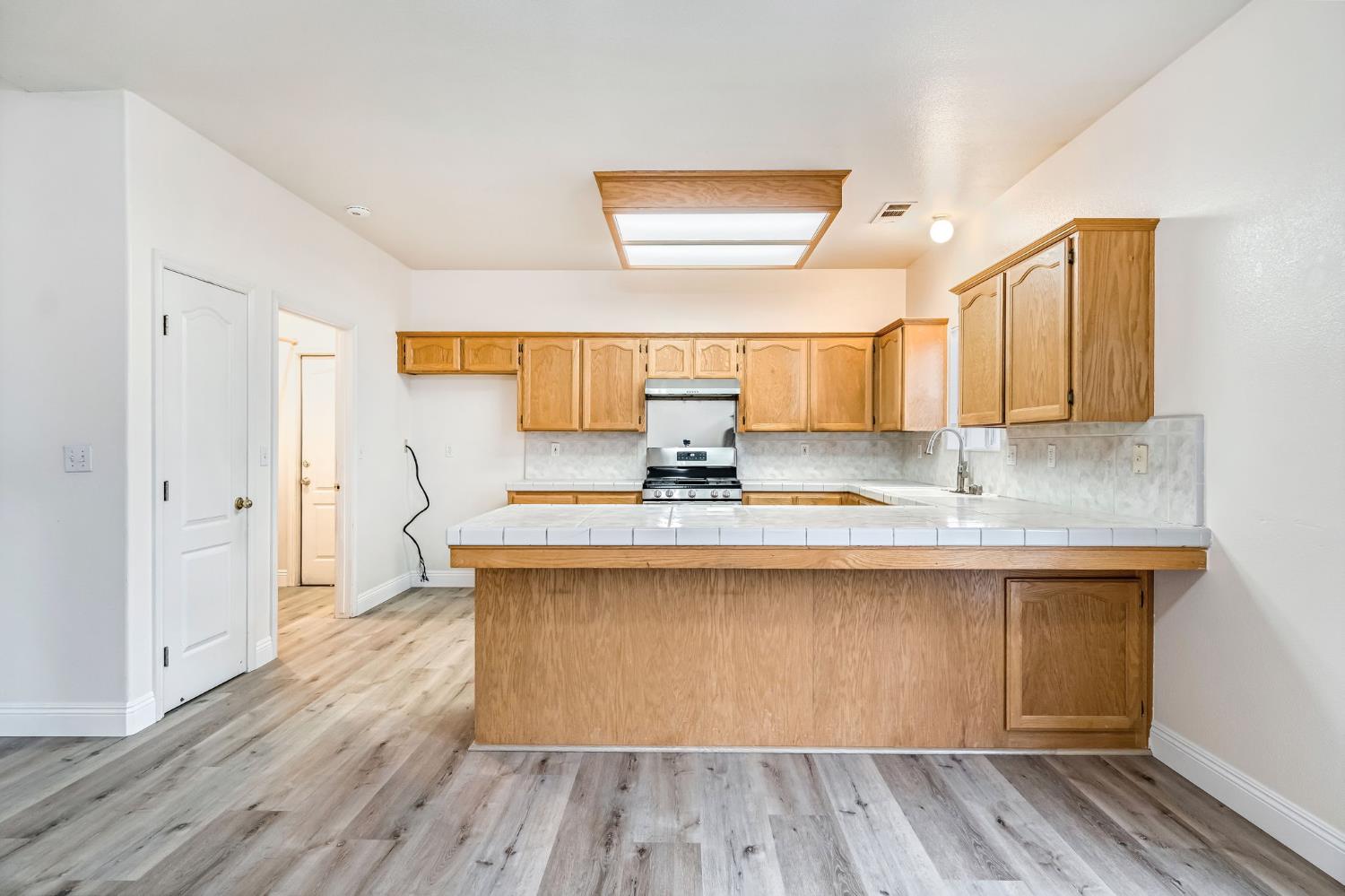 2095 Independence Place Hanford, CA 93230 - Photo 27 of 35 a kitchen with stainless steel appliances granite countertop a sink and wooden floor