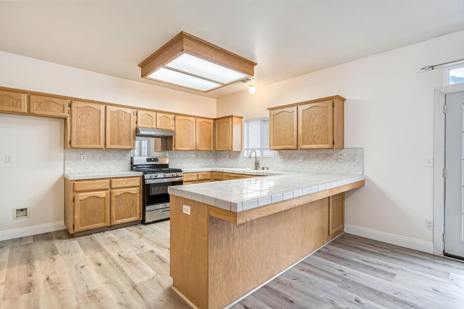 2095 Independence Place Hanford, CA 93230 - Photo 28 of 35 a kitchen with granite countertop a sink stove and wooden cabinets