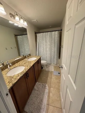 a bathroom with a granite countertop sink a mirror and a bathtub