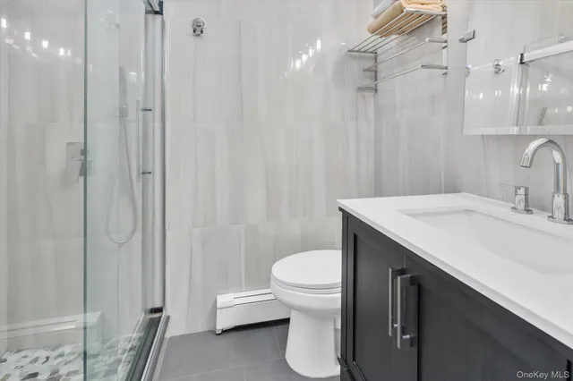 a bathroom with a sink a toilet a shower and a mirror