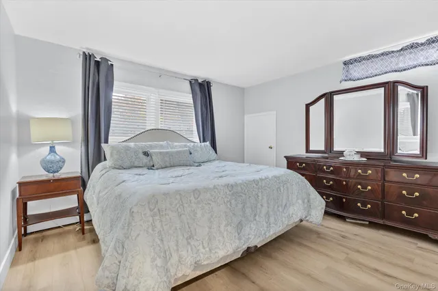 a bedroom with a bed and a dresser with mirror