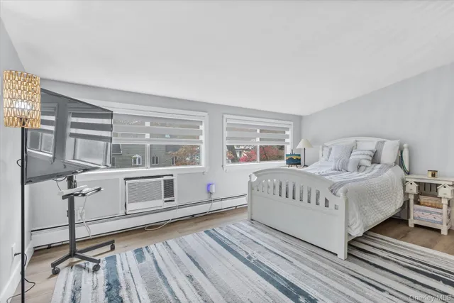 a bedroom with a white bed and windows