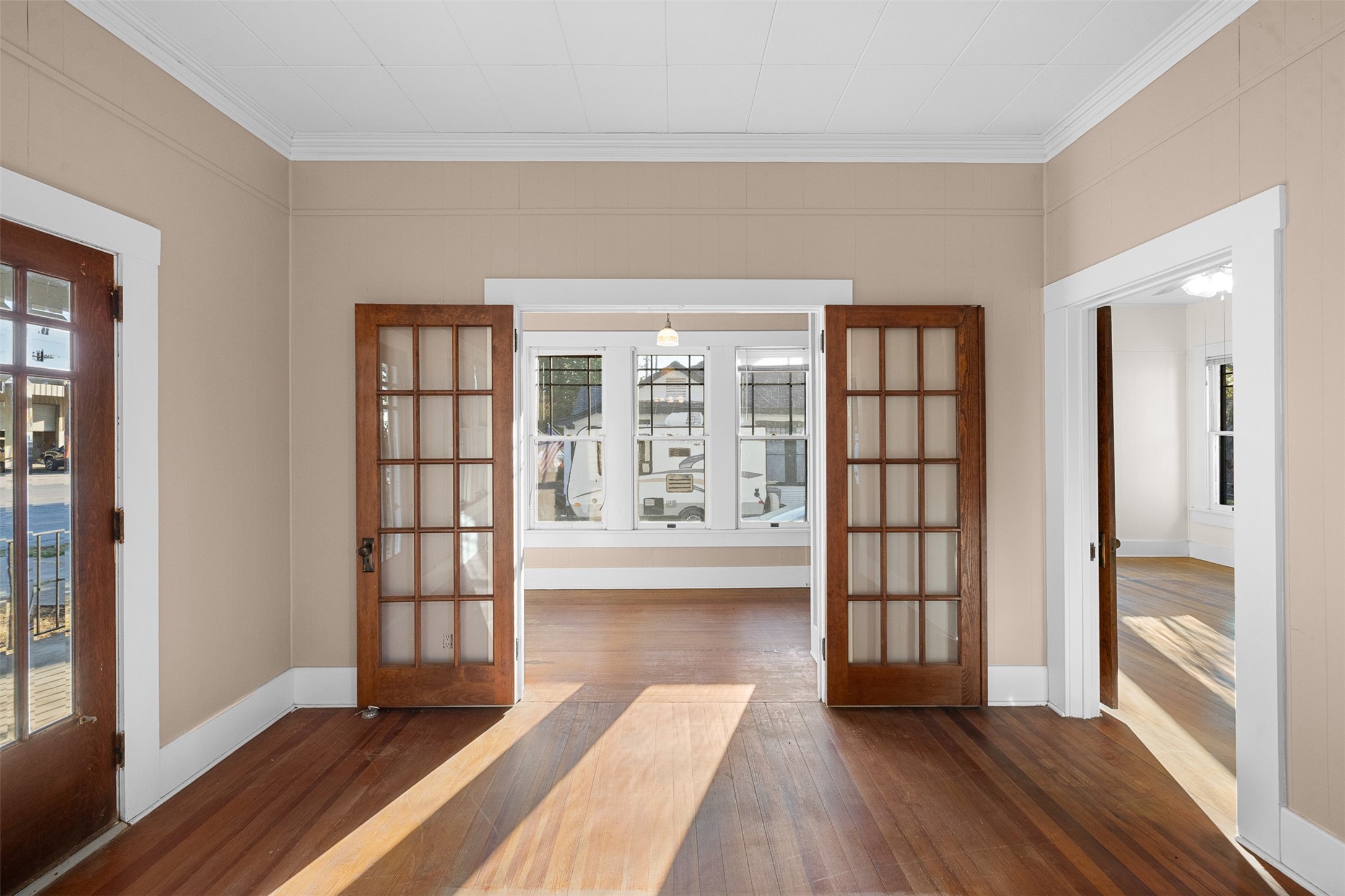 208 Summit Street Schulenburg, TX 78956 - Photo 7 of 26 an empty room with wooden floor and windows