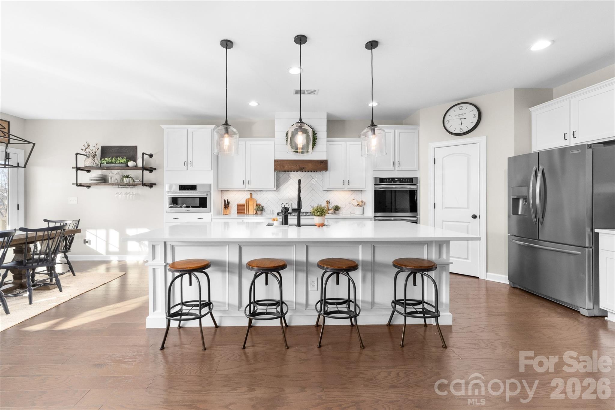 17549 Julees Walk Lane Davidson, NC 28036 - Photo 10 of 48 a kitchen with stainless steel appliances granite countertop a table chairs sink and cabinets