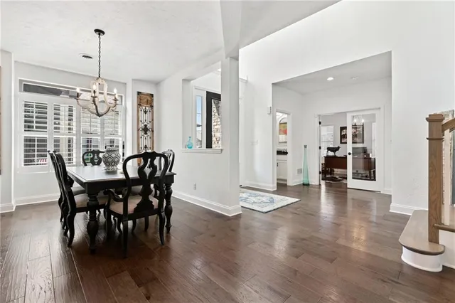 a view of a dining room and livingroom with furniture wooden floor a chandelier