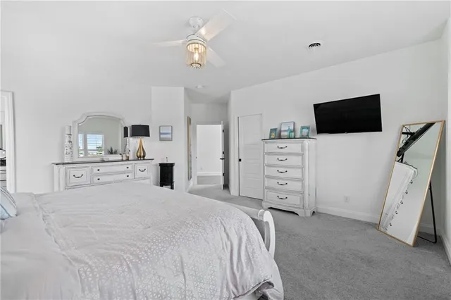 a spacious bedroom with a bed and a flat screen tv