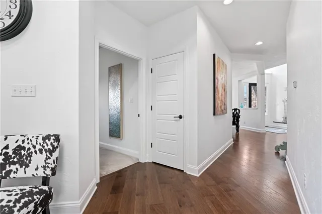 a view of a hallway with entryway wooden floor and cabinet