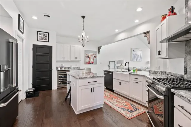 a kitchen that has a lot of cabinets in it and wooden floors