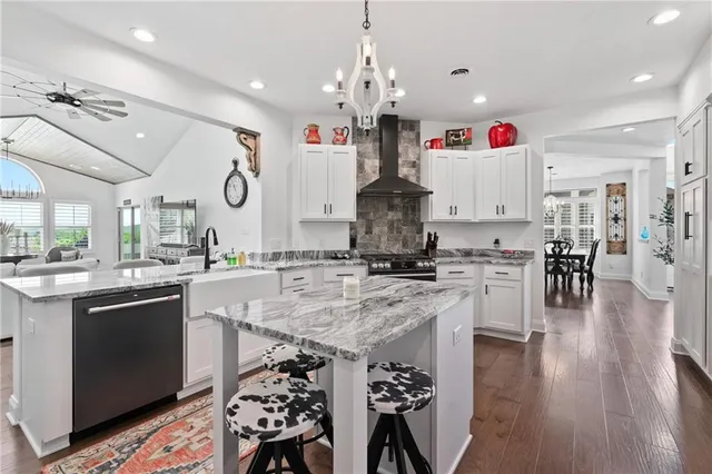 a kitchen with stainless steel appliances granite countertop a sink stove and wooden floor