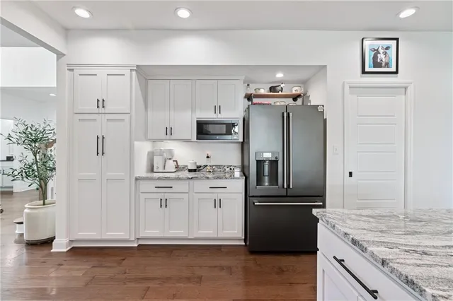 a kitchen with granite countertop a refrigerator and a sink
