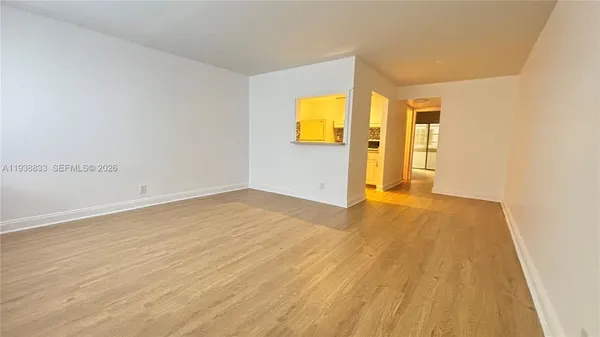 a view of empty room with wooden floor and windows