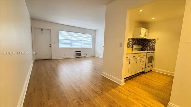 a view of a kitchen with wooden floor and a window