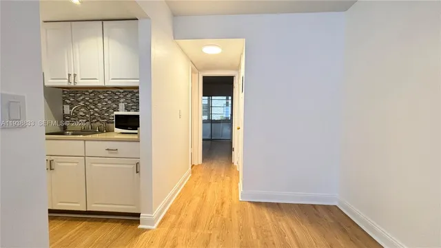 a view of a kitchen with wooden floor and cabinets
