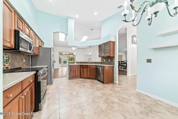 a large kitchen with stainless steel appliances granite countertop a stove a sink dishwasher and a refrigerator