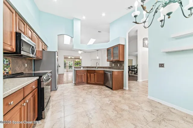 a large kitchen with stainless steel appliances granite countertop a stove a sink dishwasher and a refrigerator