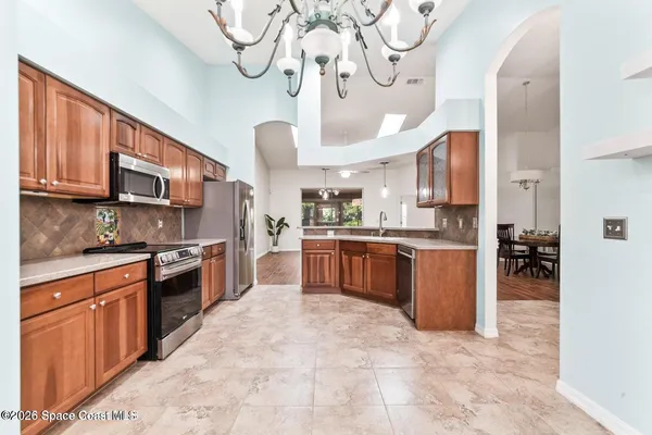 a large kitchen with stainless steel appliances granite countertop a stove granite counter tops and white cabinets