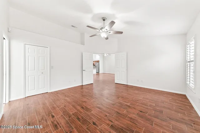 a view of an empty room with wooden floor