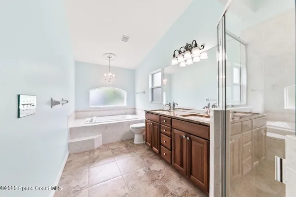 a spacious bathroom with a double vanity sink a mirror and a bathtub