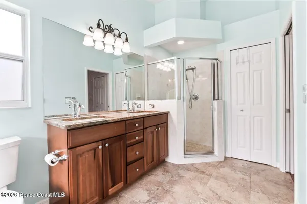 a spacious bathroom with a granite countertop sink a mirror and a shower