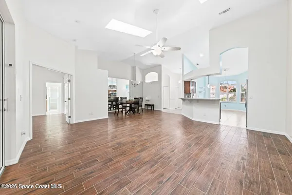 a view of a livingroom with furniture wooden floor and a ceiling fan